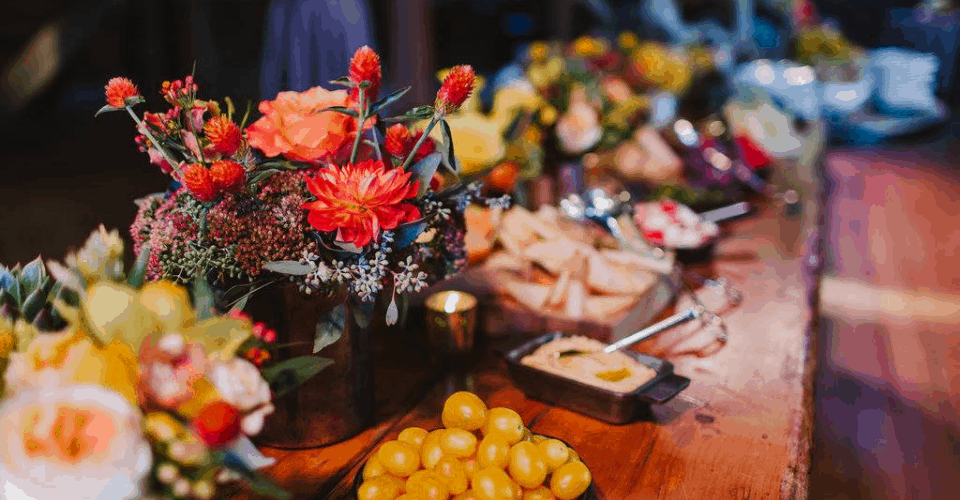 Long harvest table with vibrant florals and grazing platters